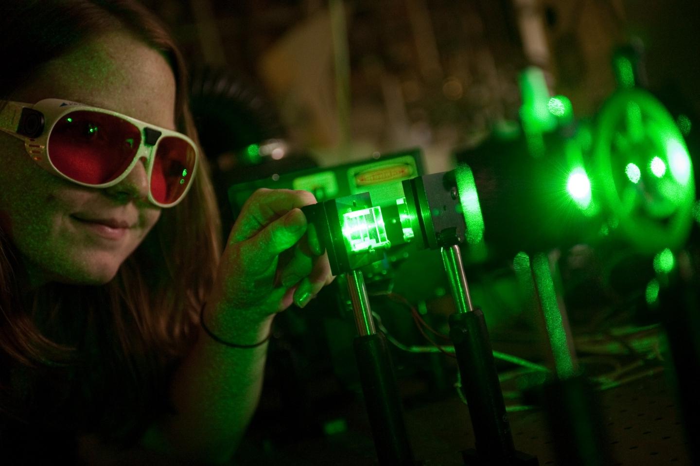 Student shining green lasers on mirrors